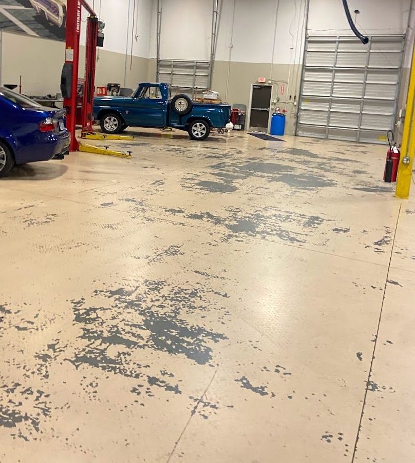 a blue truck is on a lift in a garage