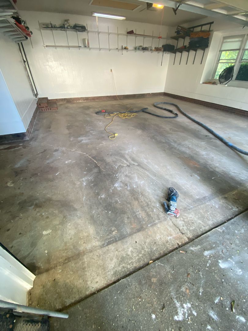 a dirty garage with a vacuum cleaner on the floor .