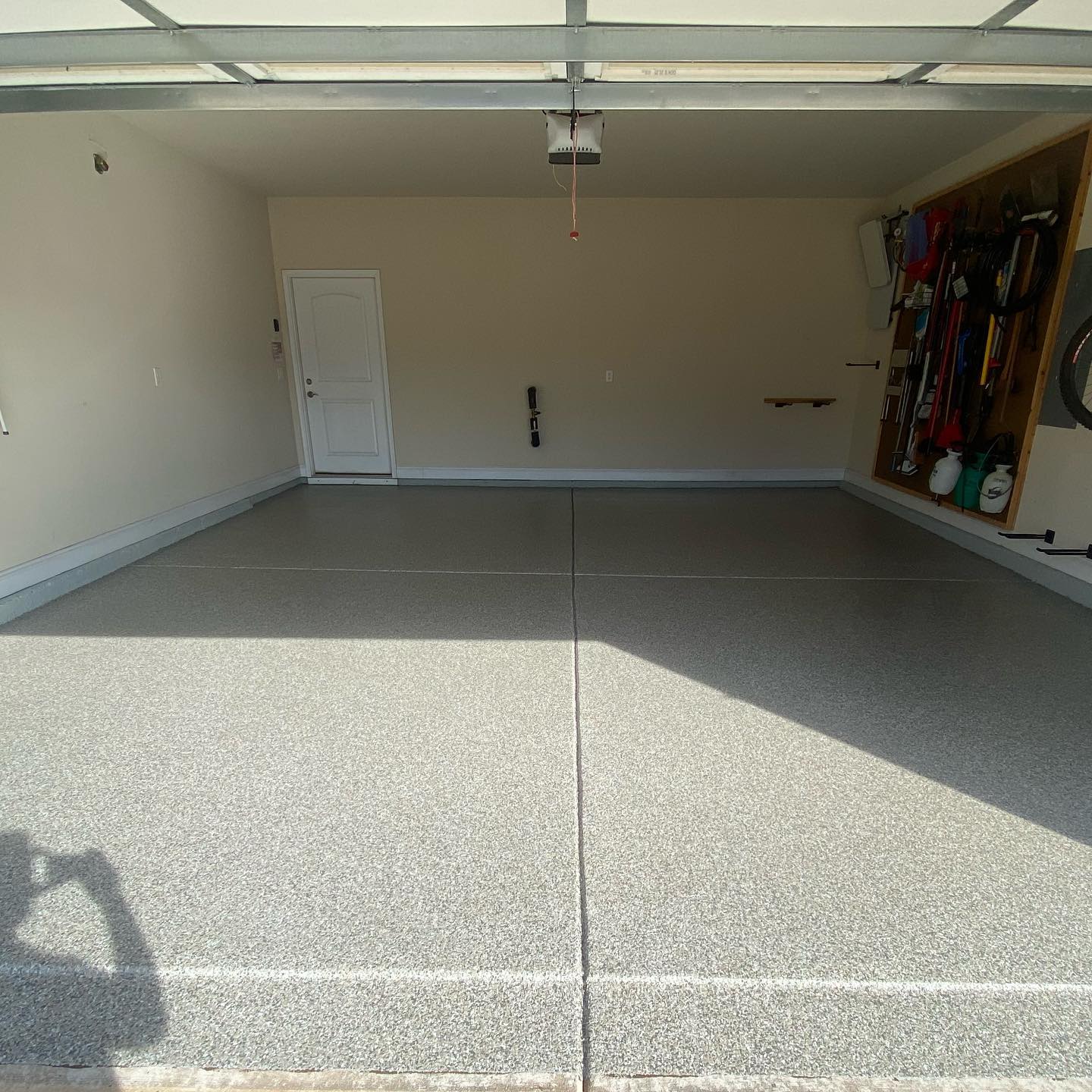 a garage with a gray floor and a white door .