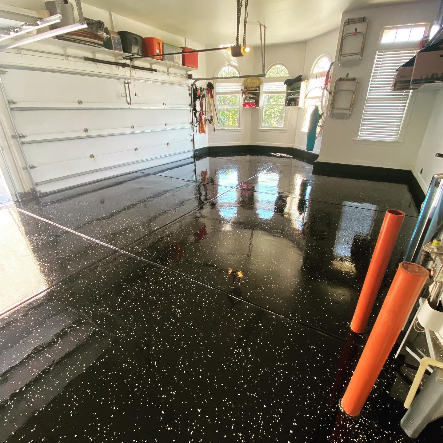 a garage with a black floor and a white garage door .