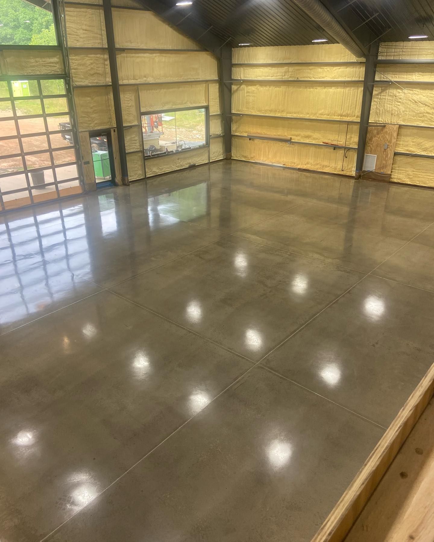 a large room with a shiny concrete floor and a garage door .
