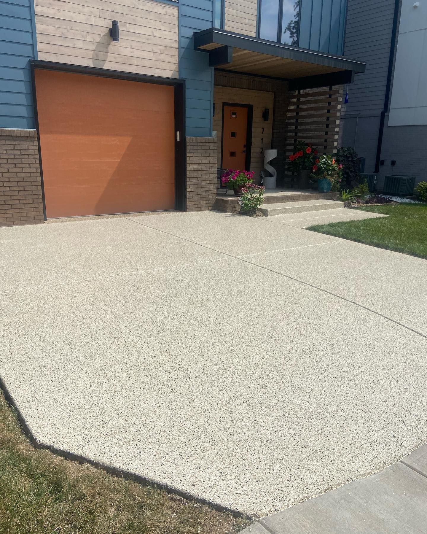a driveway in front of a house with a garage door .