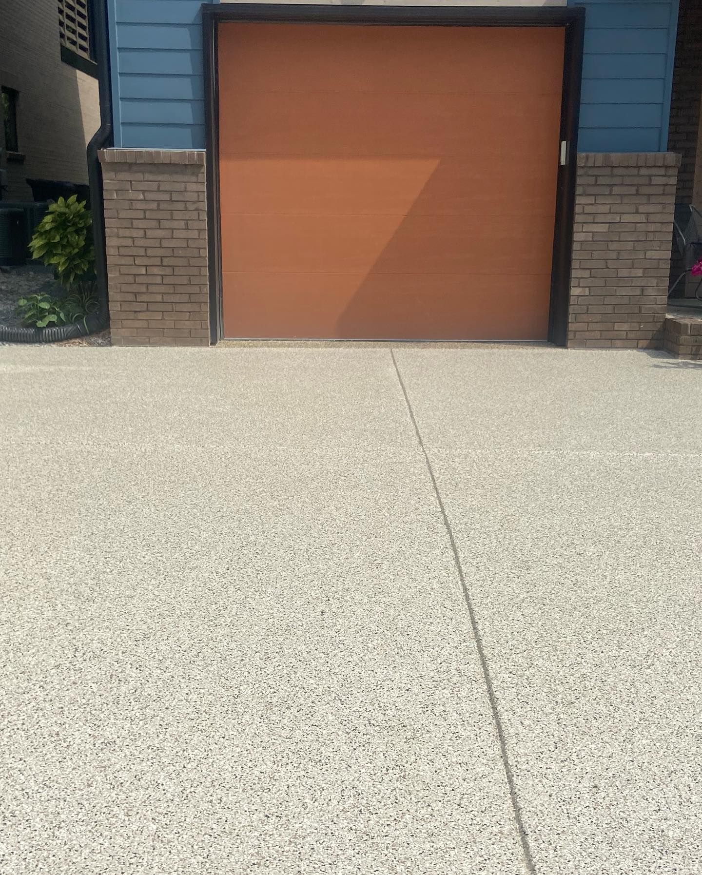 a concrete driveway with a garage door in the background