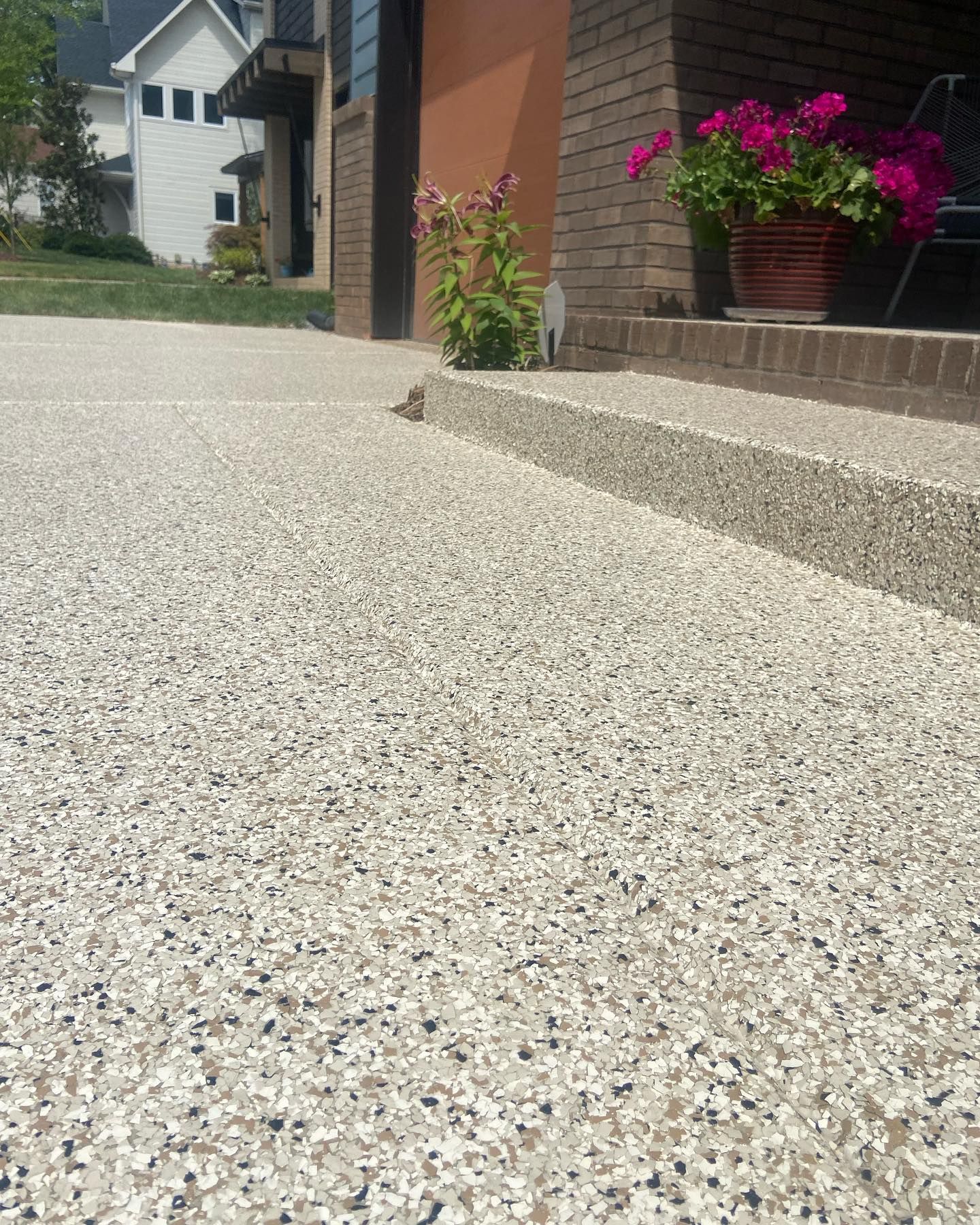 a driveway with steps and flowers in front of a house