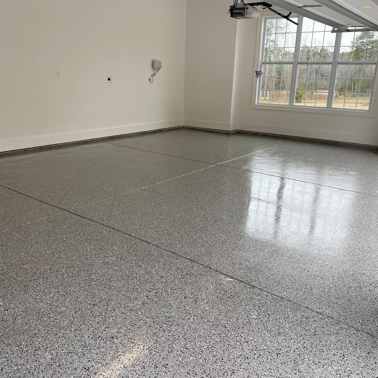 a garage with a gray floor and white walls .