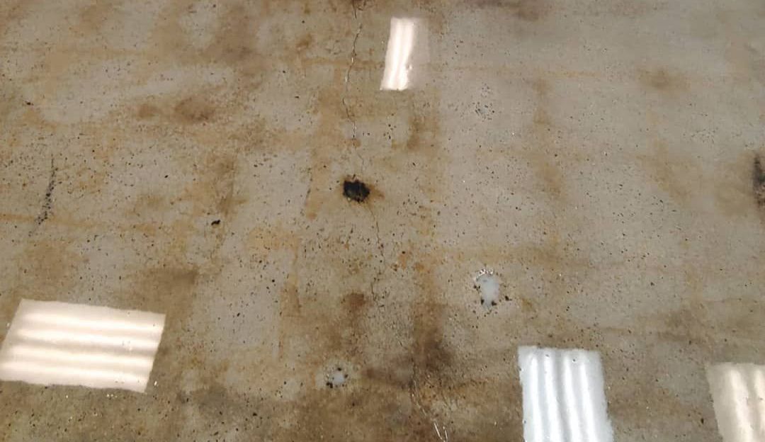 a close up of a dirty concrete floor with a reflection of lights .
