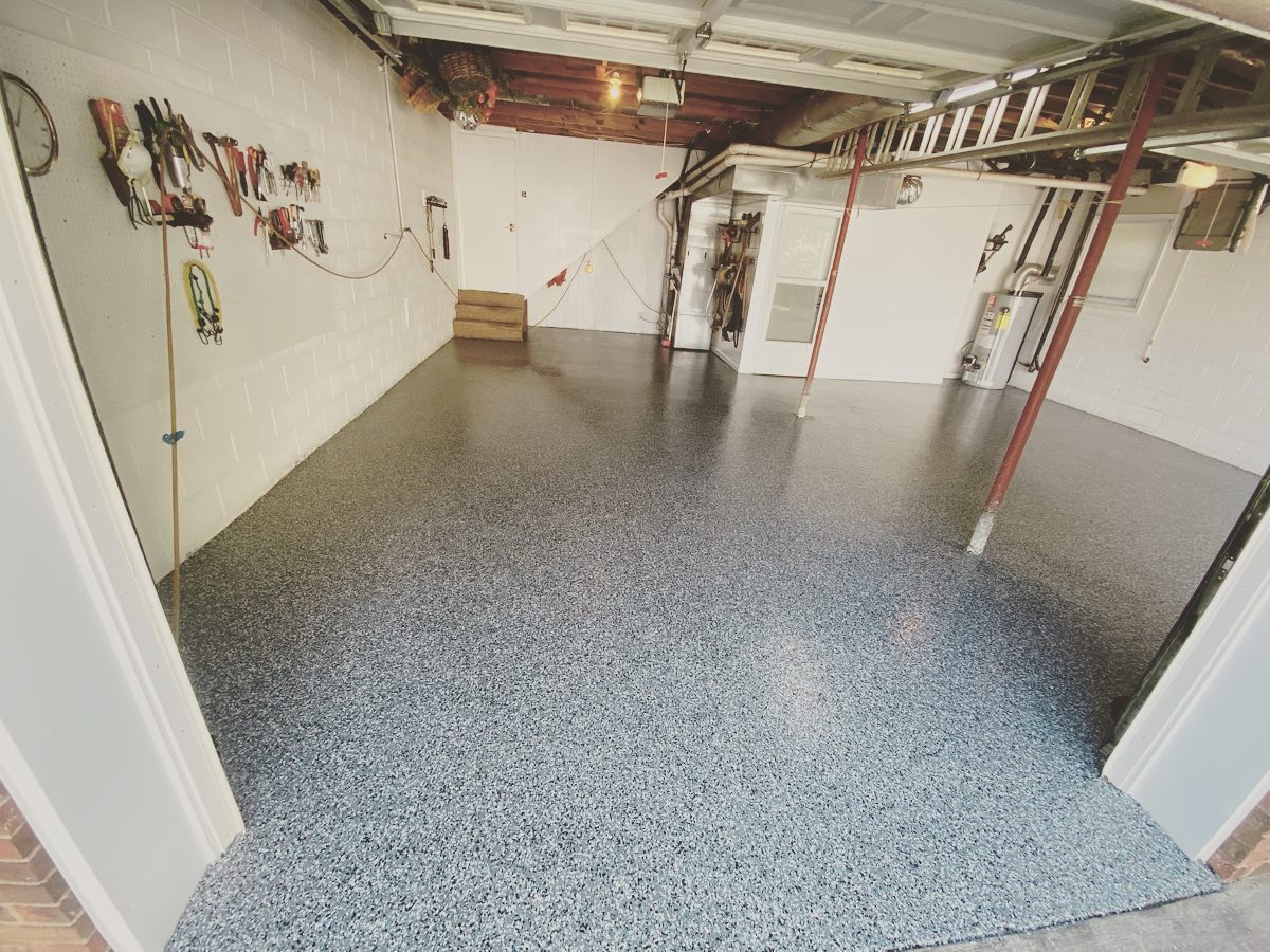 a garage with a gray floor and white walls .