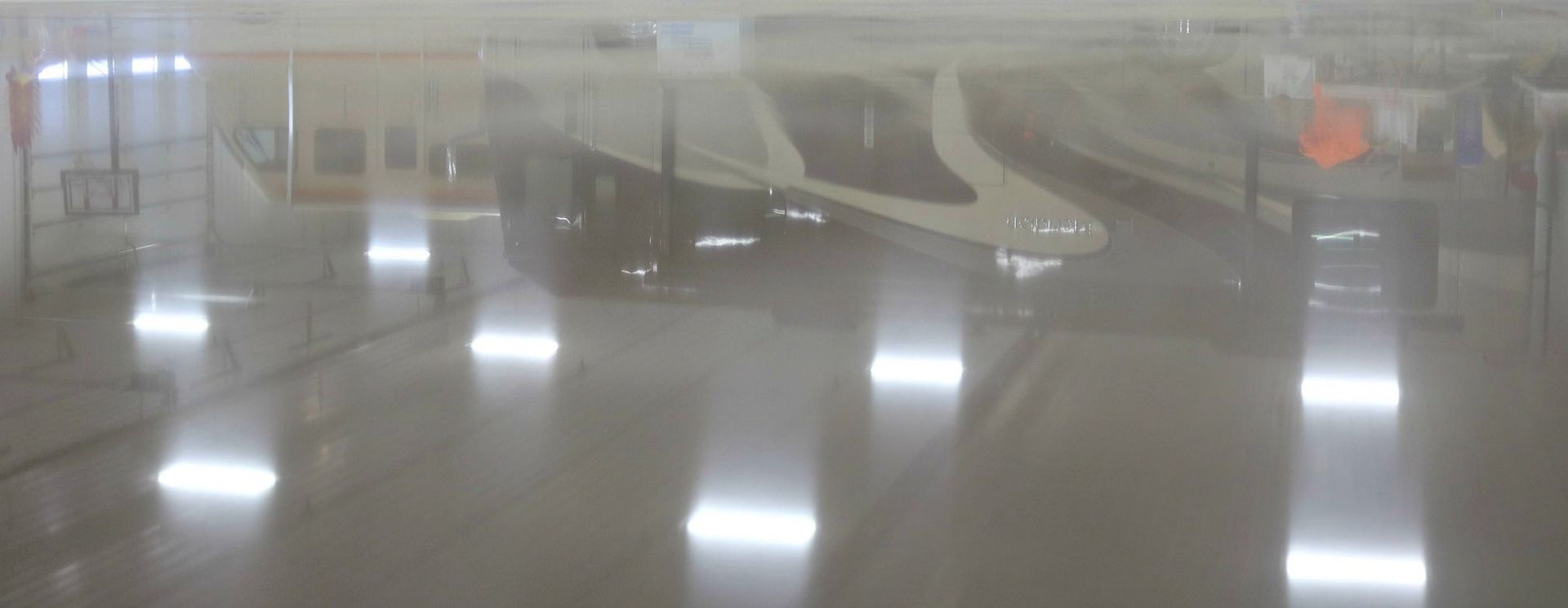 a row of trains are parked in a train station covered in fog .