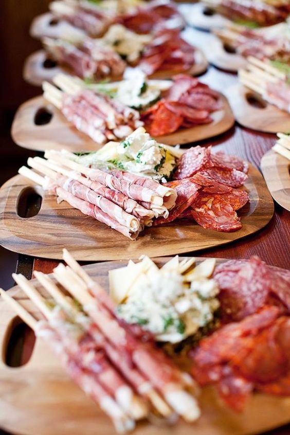 A variety of meats and cheeses on wooden cutting boards on a table — The Larder Byron Bay in Byron Bay, NSW