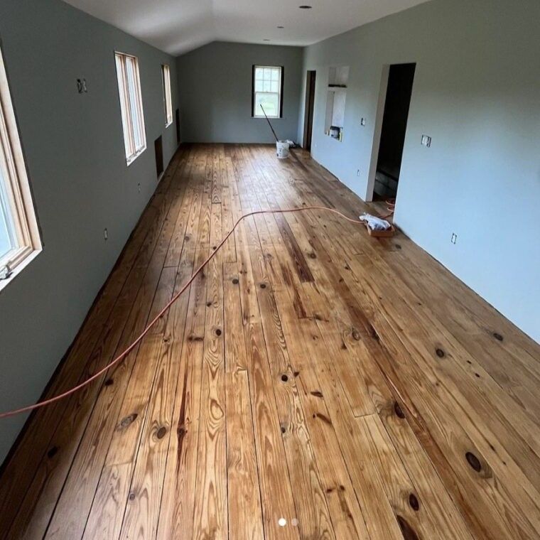 A large room with wooden floors and gray walls