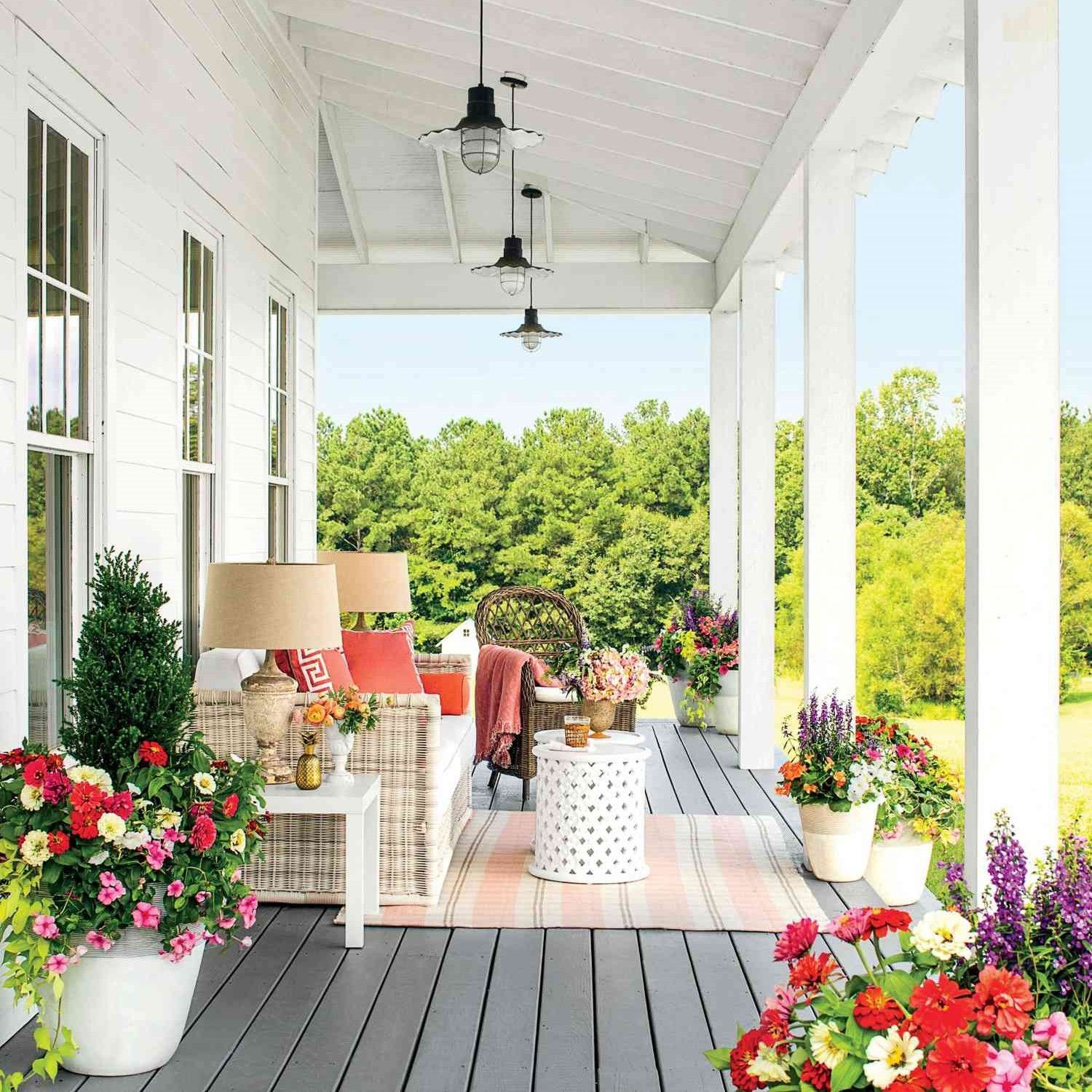 A porch with a lot of flowers and furniture on it