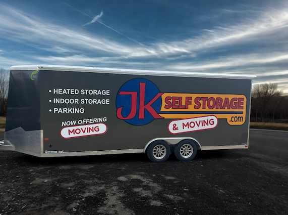 Trailer for JK Self Storage & Moving, with “heated storage,” “indoor storage,” and “parking” informational decals.