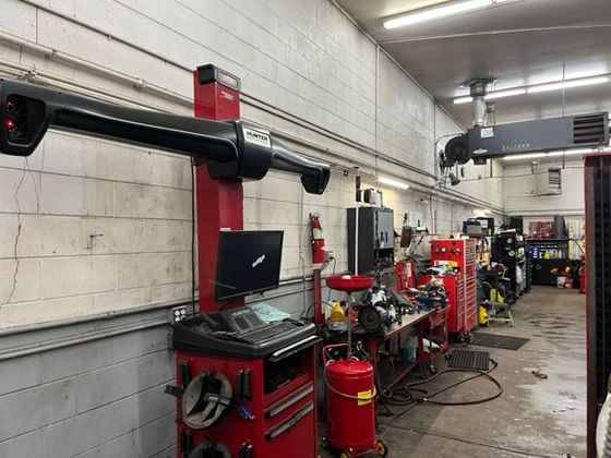 A red machine is sitting in the middle of a garage.