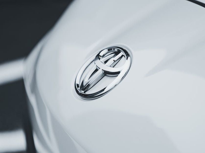 A close up of a toyota emblem on a white car