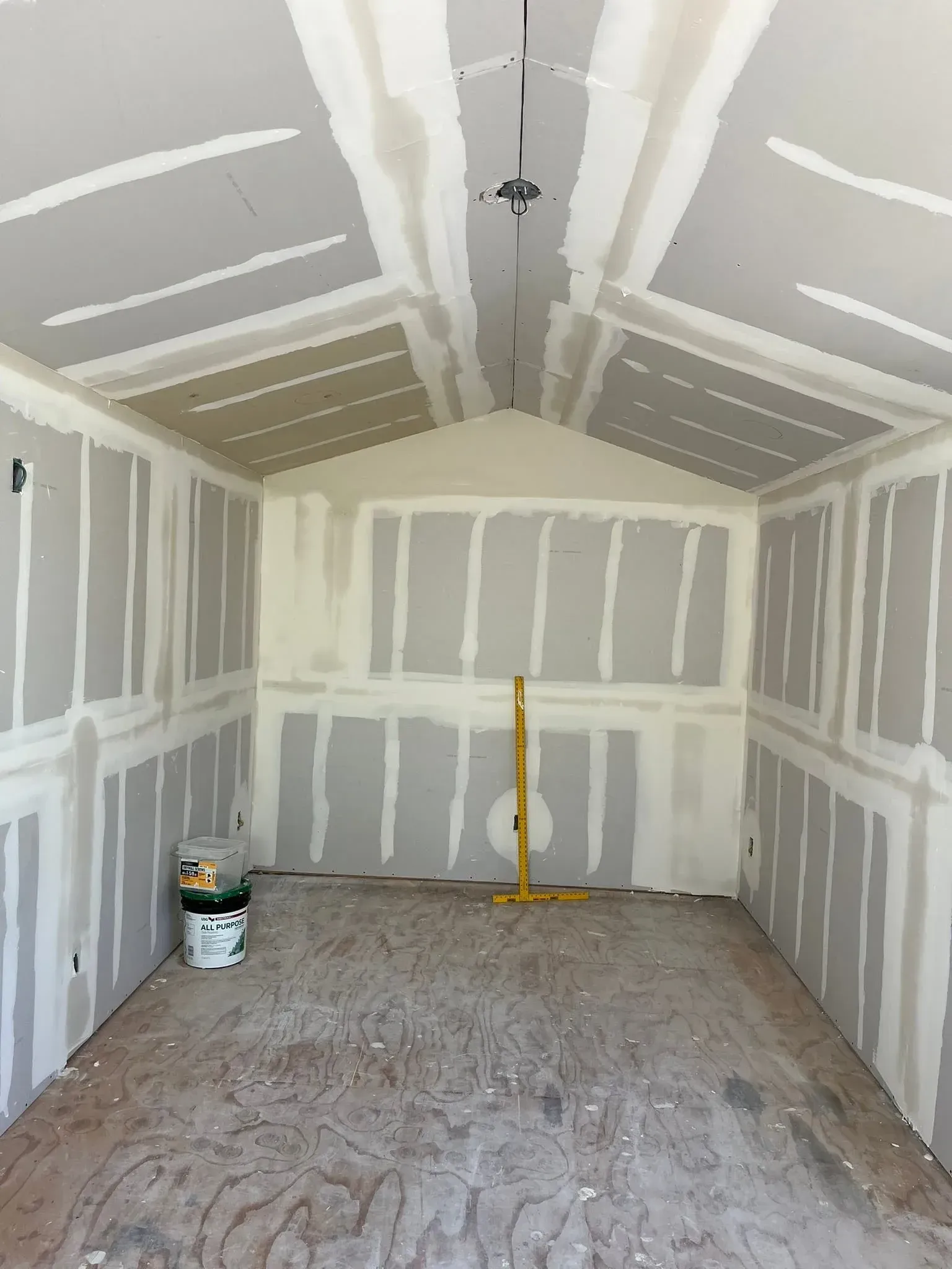 Newly installed drywall with taped and mudded seams in a vaulted-ceiling room in Tempe, AZ