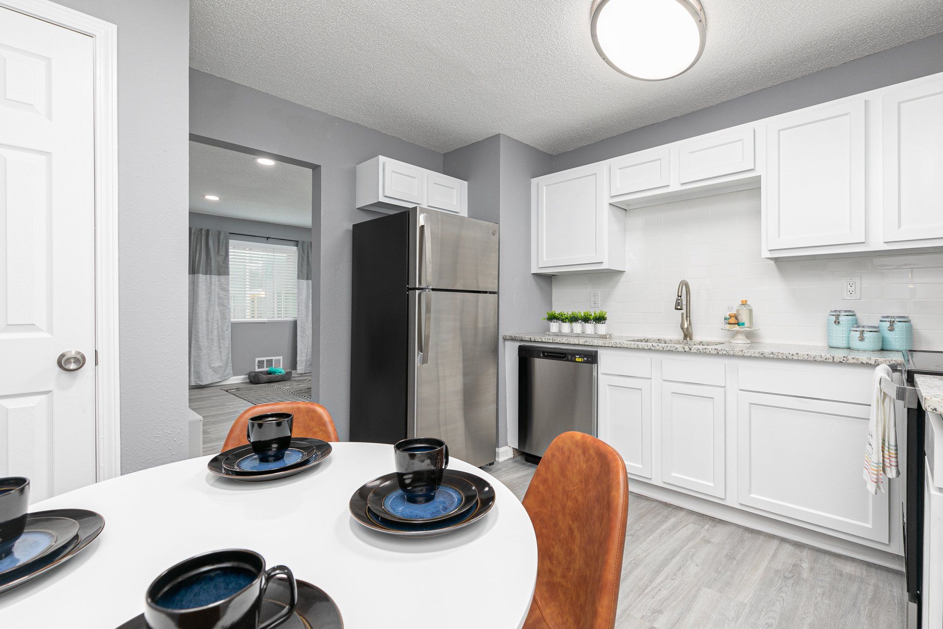 2-Bedroom Apartments in Sylvan Hills, GA - Gateway South Apartments - Open Concept Kitchen with Stainless Steel Appliances, Faux Wood Flooring, and White Cabinets