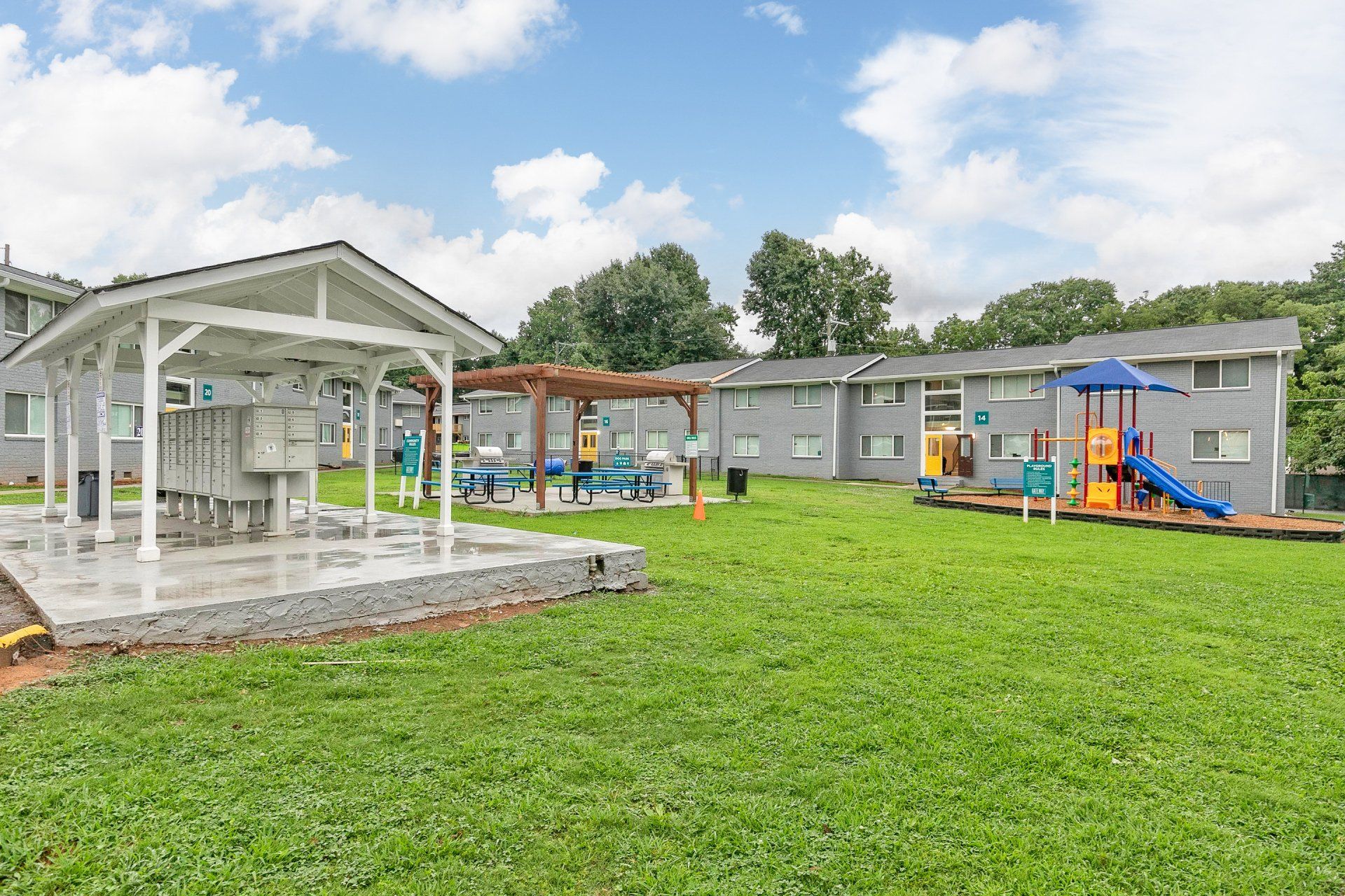 One-Bedroom Apartments In Sylvan Hills, GA - Gateway South - Lush Green Space With Playground, Picnic Tables Under Pergola, And Grilling Area.