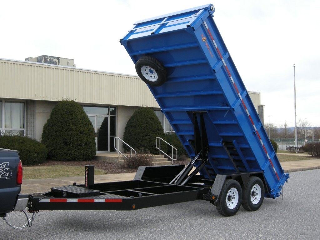 A white dump truck is parked in front of a building.