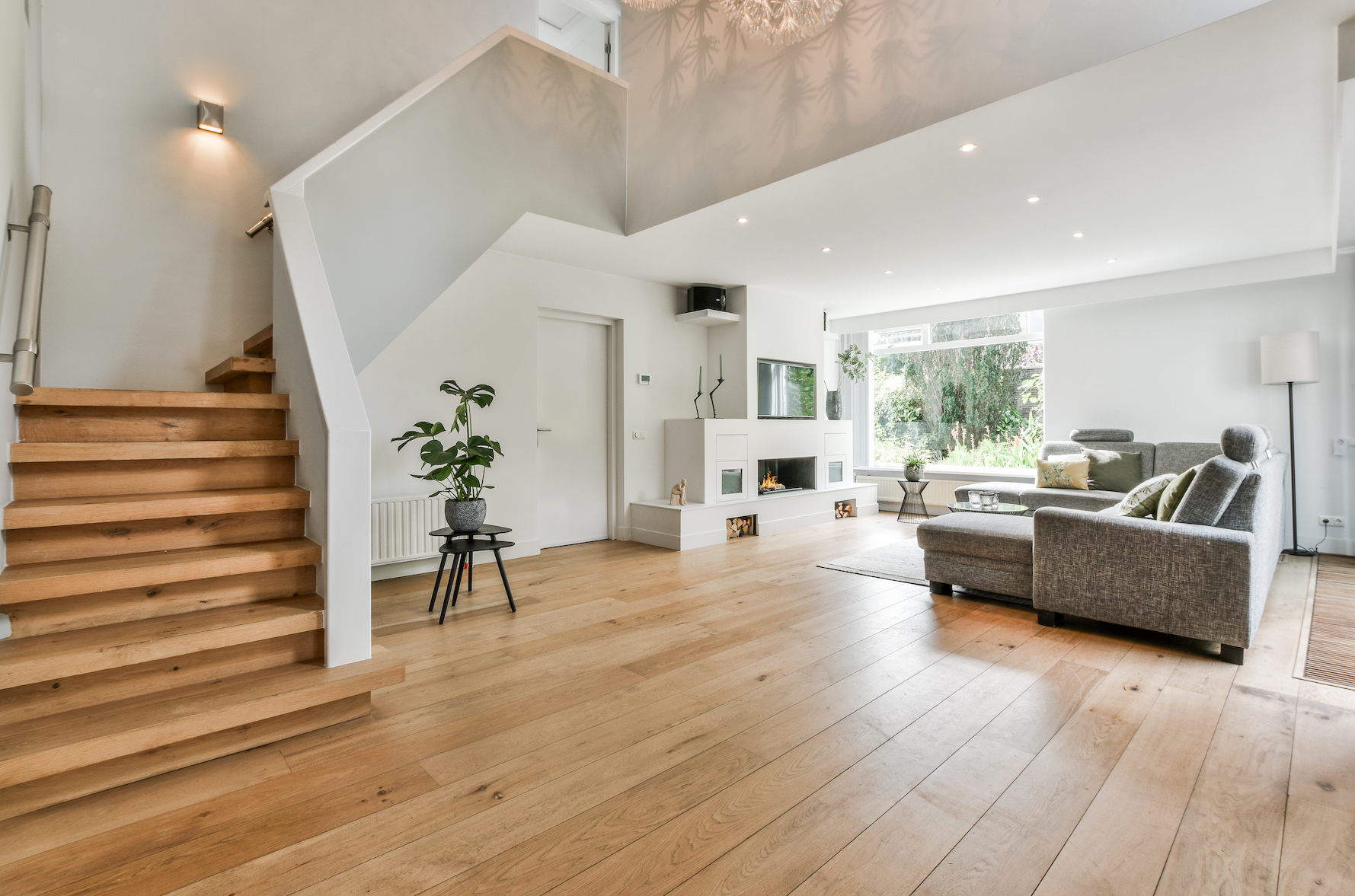 A living room with hardwood floors and stairs leading up to the second floor.