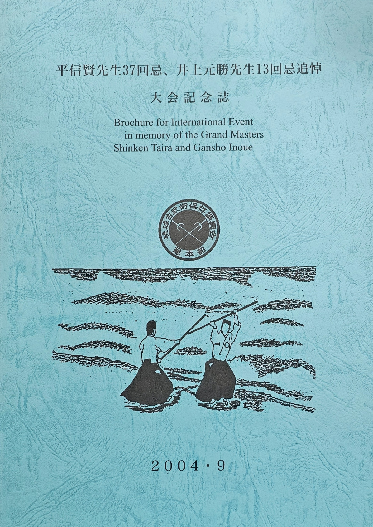 Blauwe Chinese publicatieomslag met tekst, een rond embleem en een zwarte lijntekening van figuren op water; gedateerd 2004.