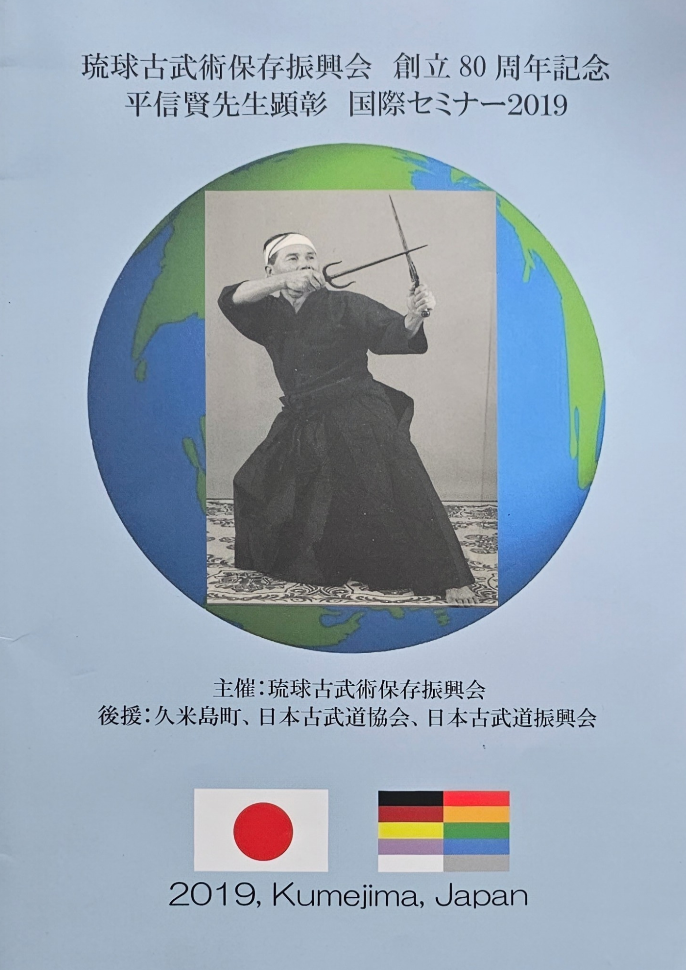 Poster met een zwart-wit silhouet van een zwaardvechter boven een wereldbol, Japanse tekst en onderaan 