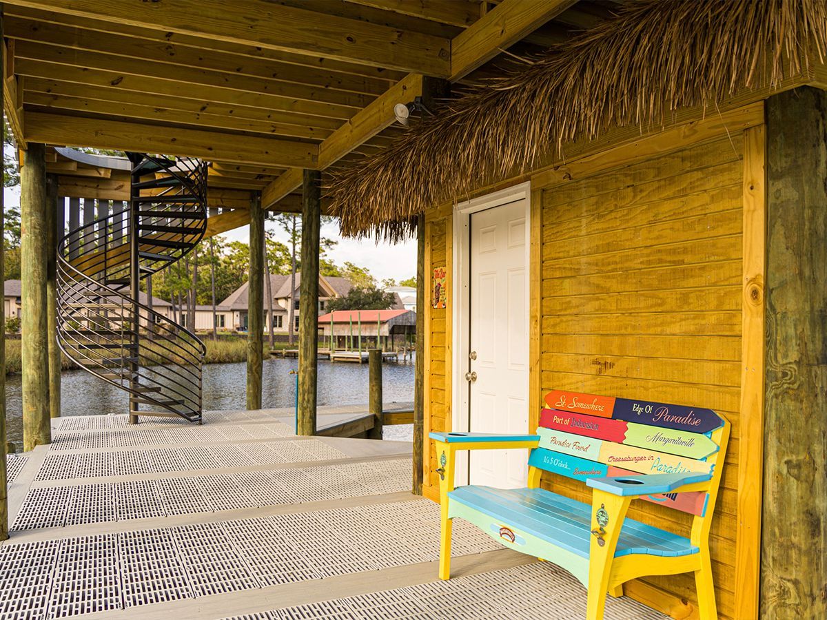 A colorful bench is sitting on a wooden dock.