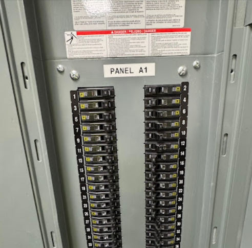 Electrical panel labeled “PANEL A1” with rows of circuit breakers and numbered switches.