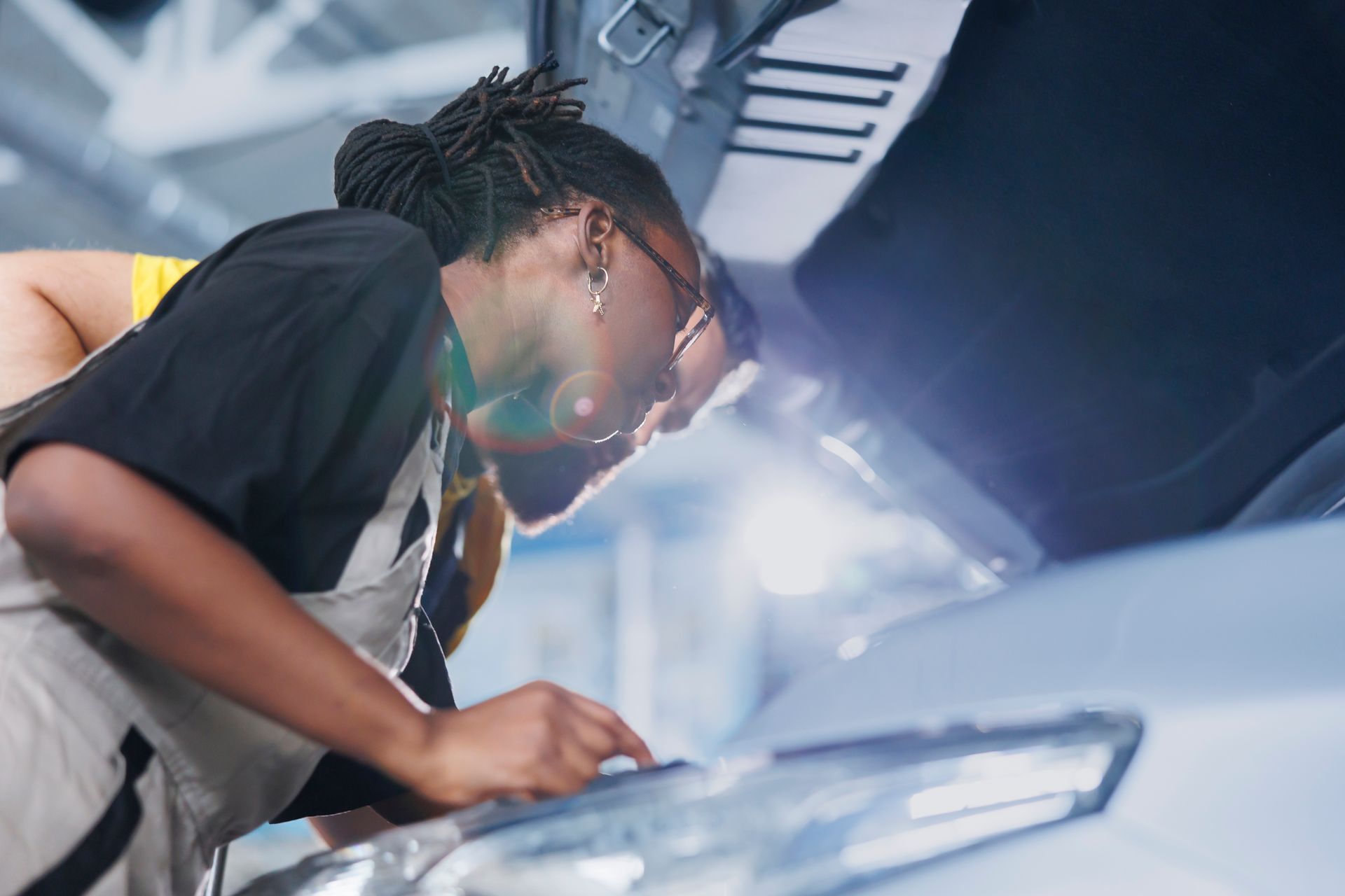A man is working on a car engine with a wrench.