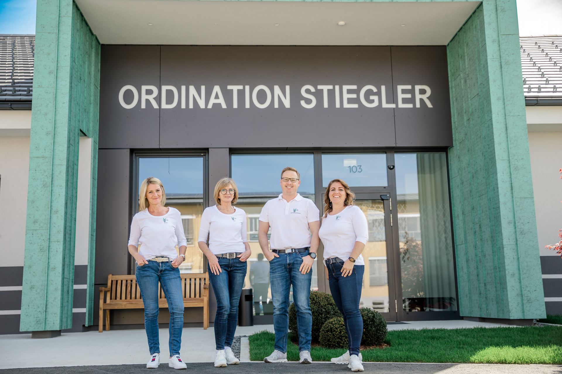 Eine gruppe von menschen steht vor einem gebäude mit der aufschrift „ordination stiegler“.