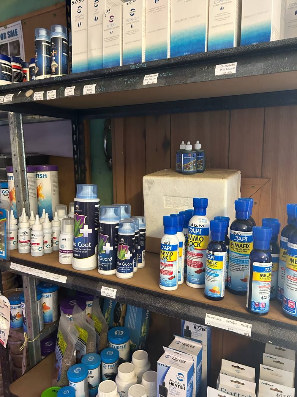 A Shelf Filled With Lots of Bottles and Boxes of Fish Supplies — Barnyard Stockfeed, Pet, Garden and Florist in Childers, QLD