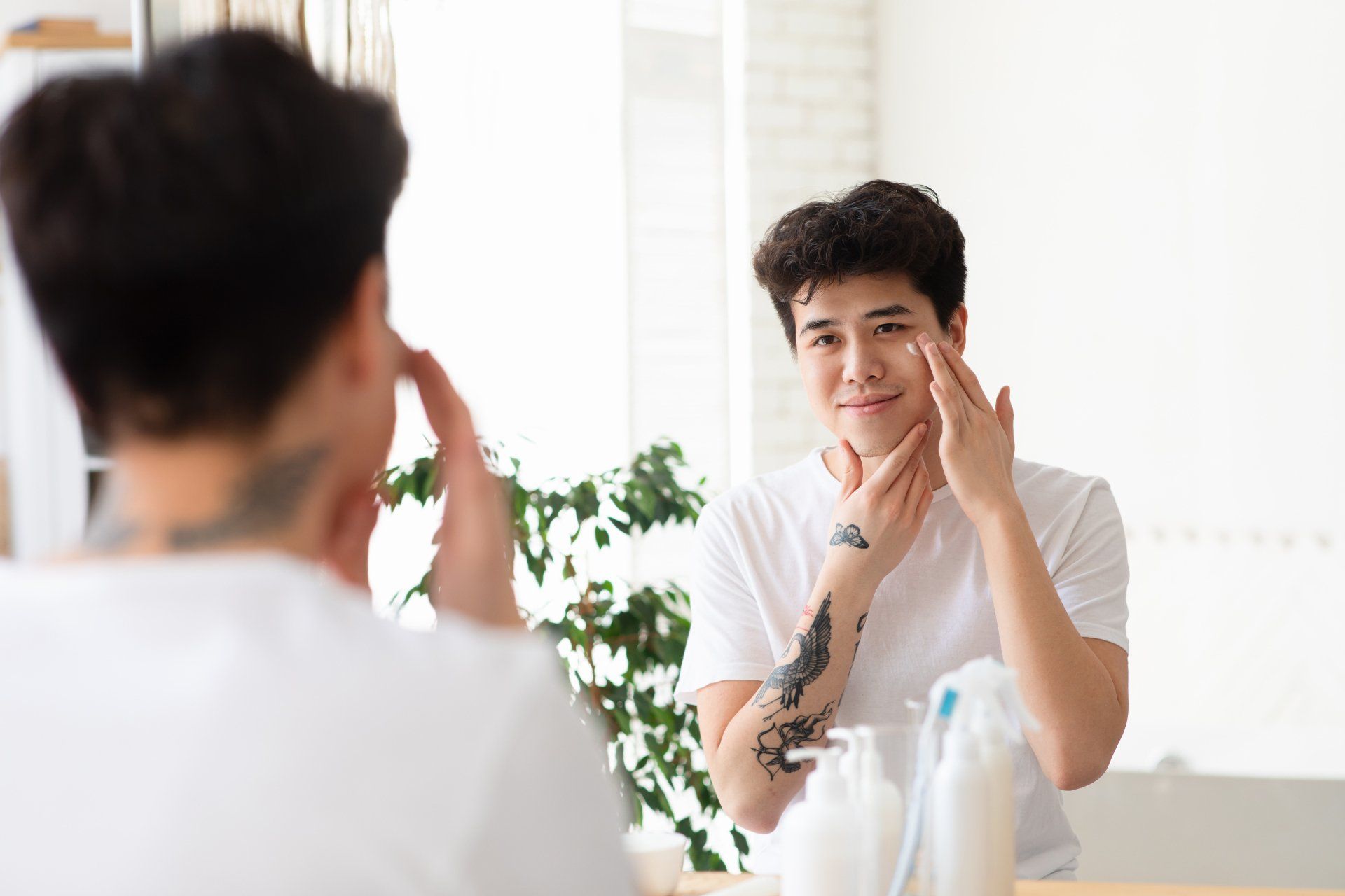 a guy applying skin lotion on his face