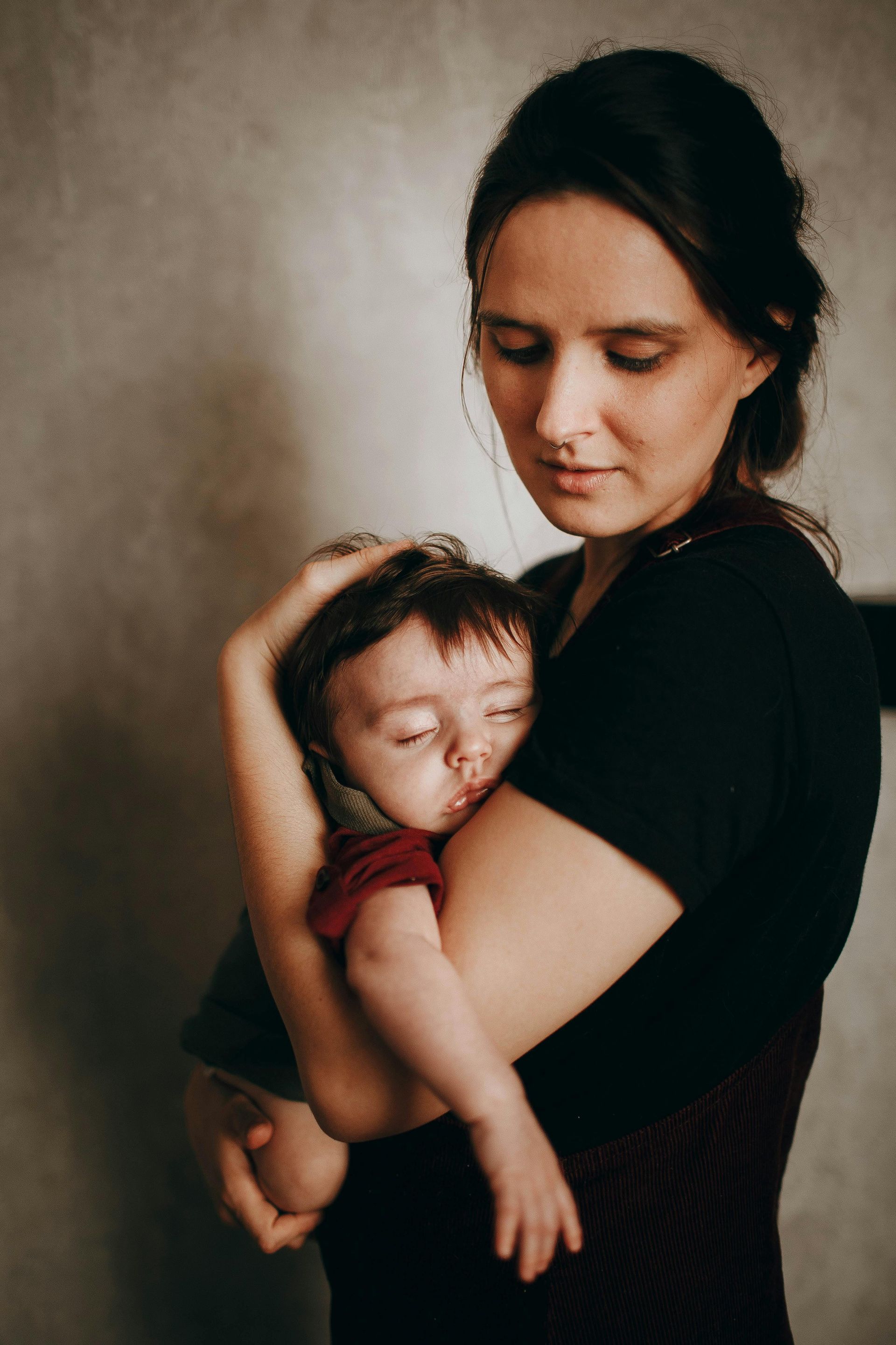 A woman is holding a baby in her arms.