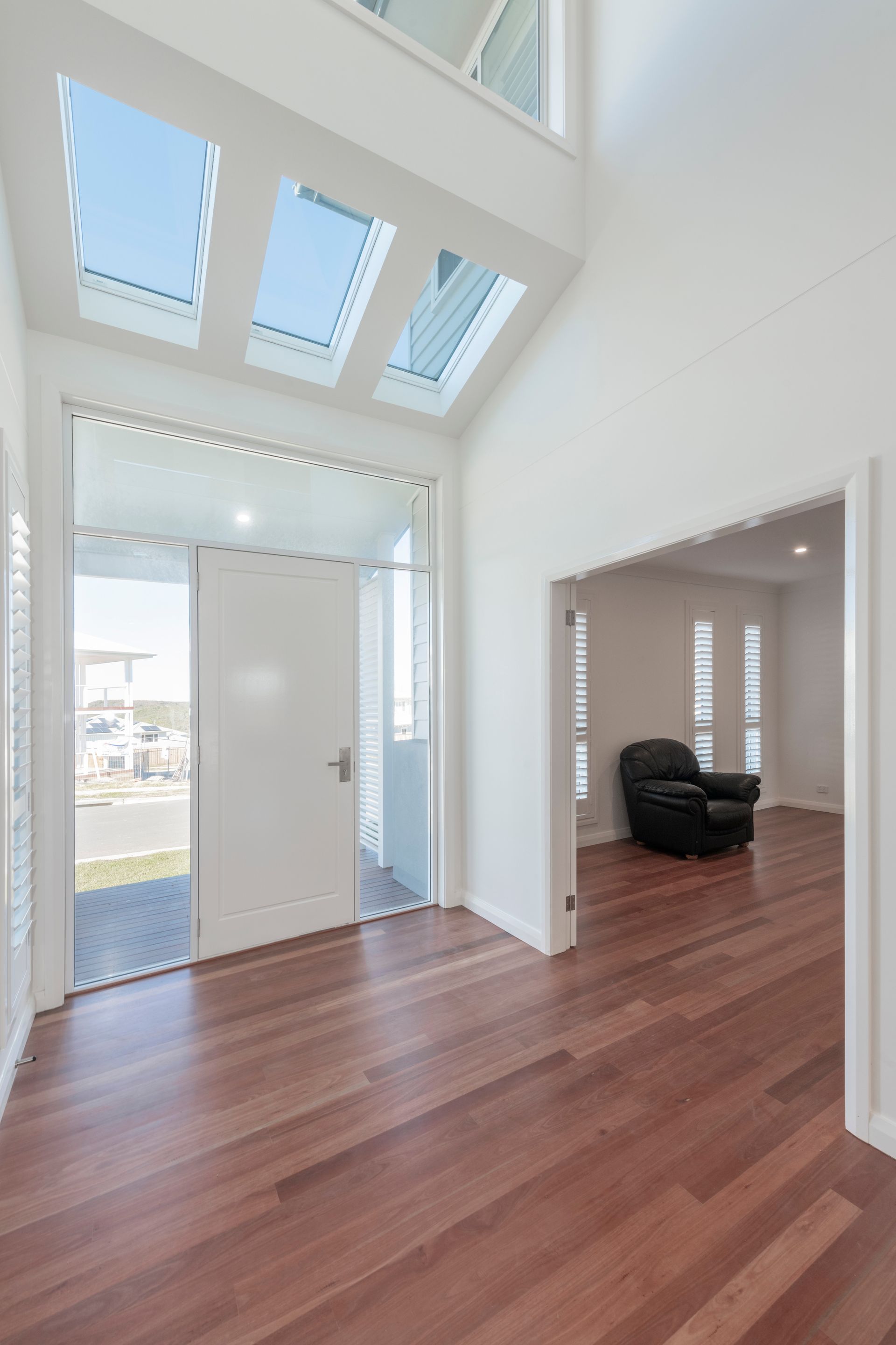 Interior View of a Modern Home Entryway With Wood Floors and Open Front Door — Indie Living In Lake Macquarie, NSW