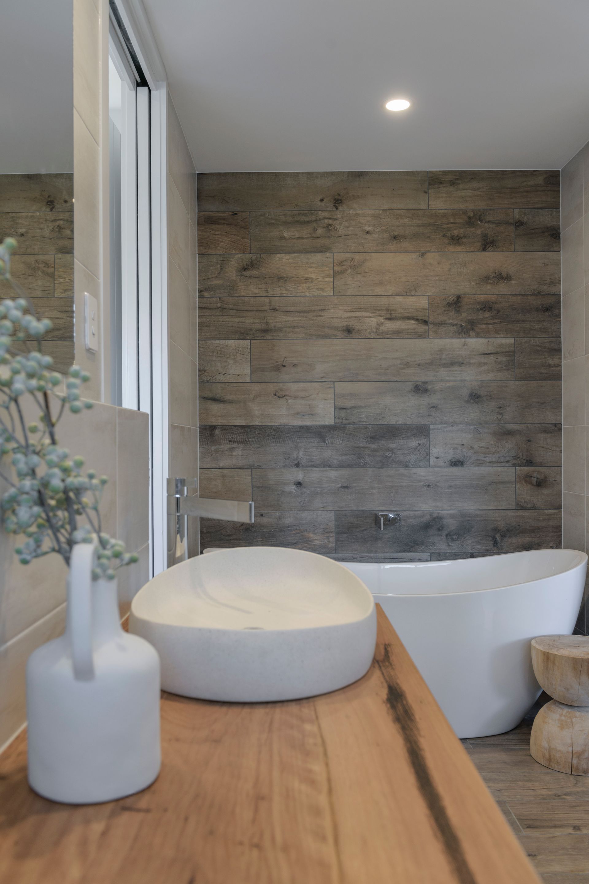 Bathroom With Wood-look Wall, White Tub and Sink — Indie Living In Lake Macquarie, NSW