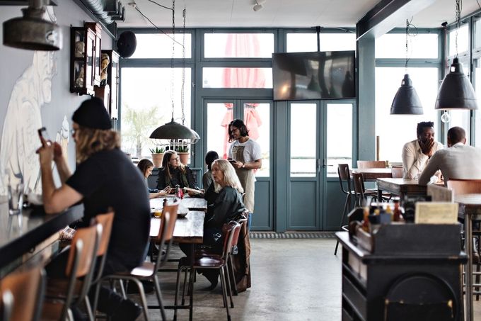 A group of people are sitting at tables in a restaurant.