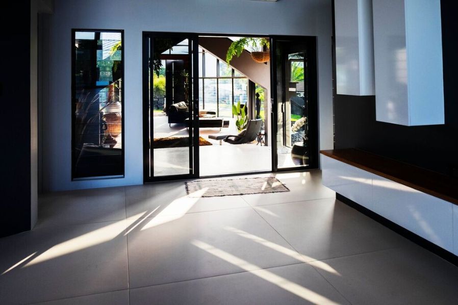 An Empty Room With a Sliding Glass Door and a Staircase — Omni Builders In Bungalow, QLD