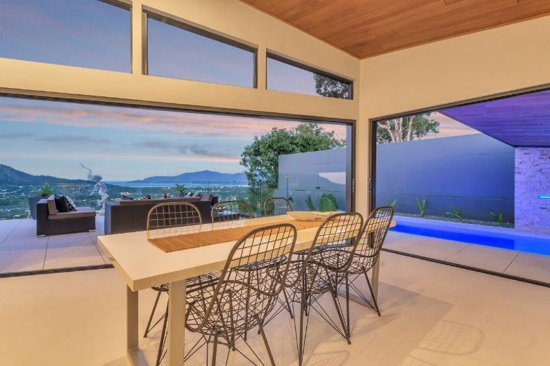 A Dining Room With a Table and Chairs and a View of a Pool — Omni Builders In Bungalow, QLD