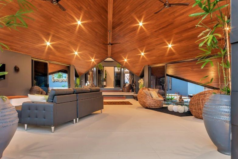 A Living Room With a Couch , Chairs , and a Wooden Ceiling — Omni Builders In Bungalow, QLD