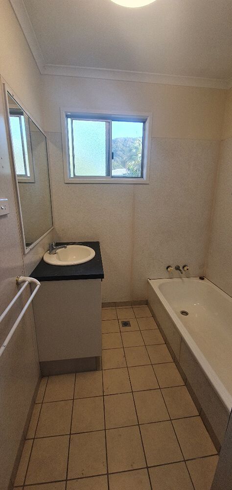 A Bathroom With a Sink , Tub , Mirror and Window — Omni Builders In Bungalow, QLD