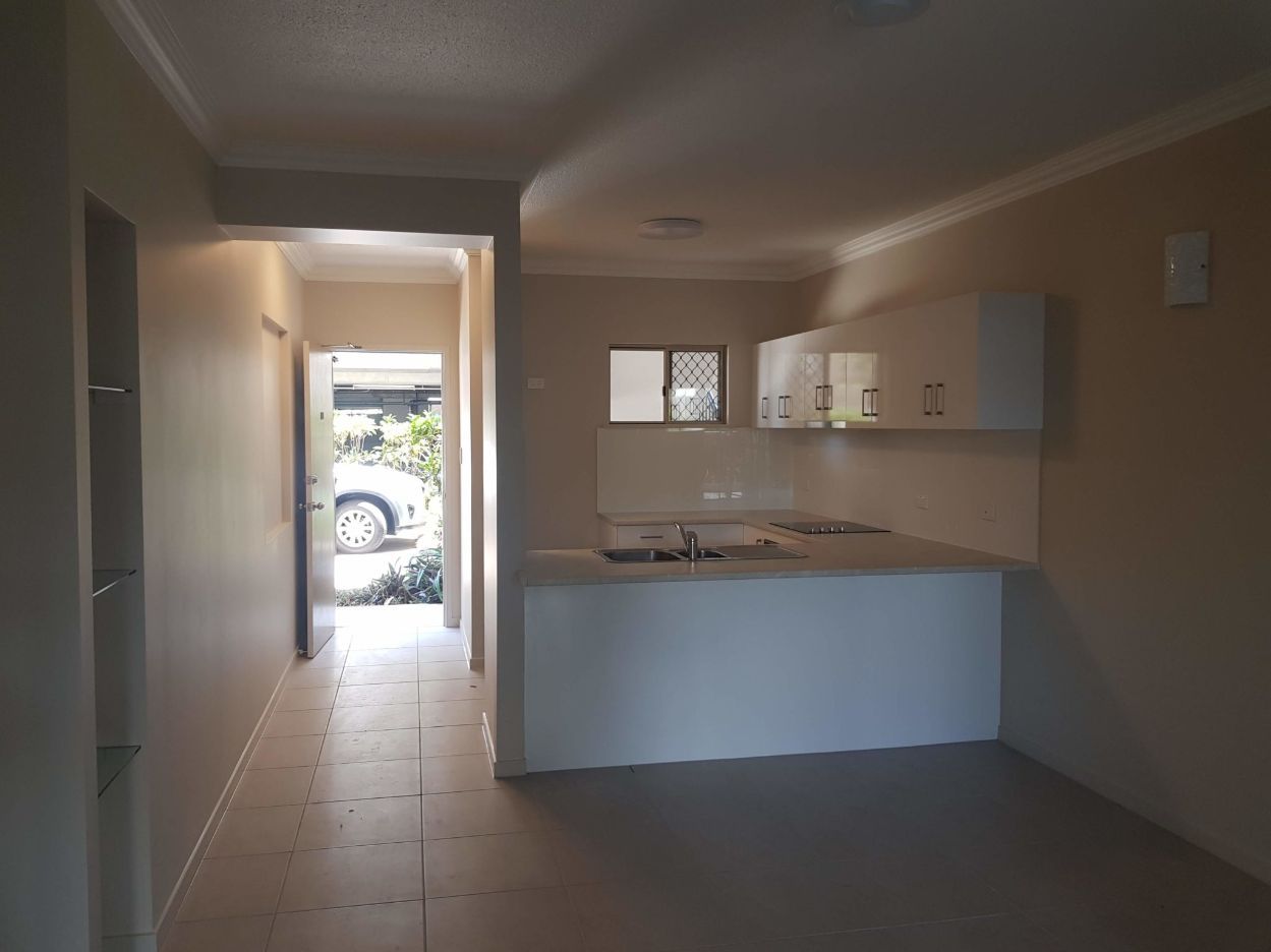 An Empty Kitchen With White Cabinets and a Sink — Omni Builders In Bungalow, QLD