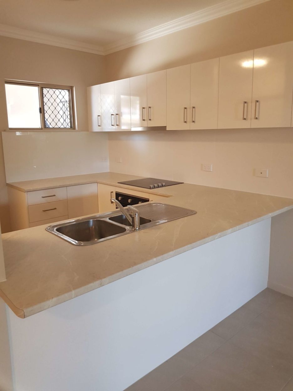 An Empty Kitchen With White Cabinets and a Sink — Omni Builders In Bungalow, QLD