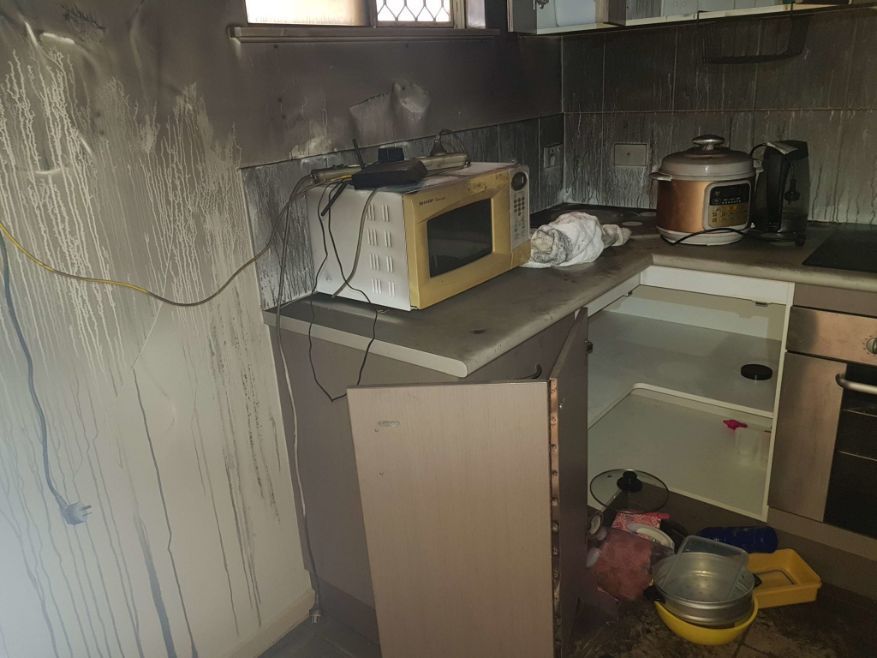 A Kitchen With a Microwave and a Stove in It — Omni Builders In Bungalow, QLD