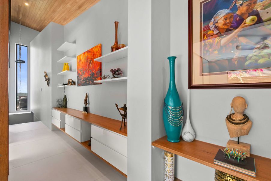 A Hallway With Shelves and a Picture on the Wall — Omni Builders In Bungalow, QLD