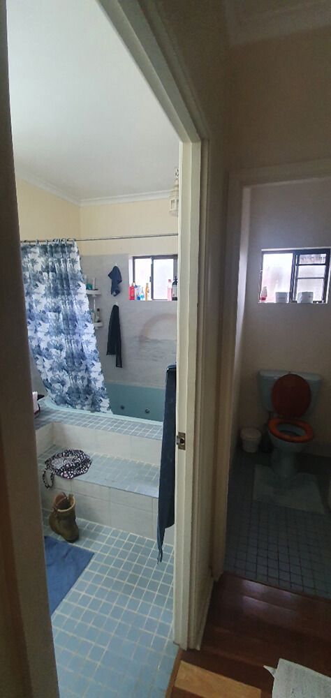 A Bathroom With a Tub , Shower Curtain , and Toilet — Omni Builders In Bungalow, QLD