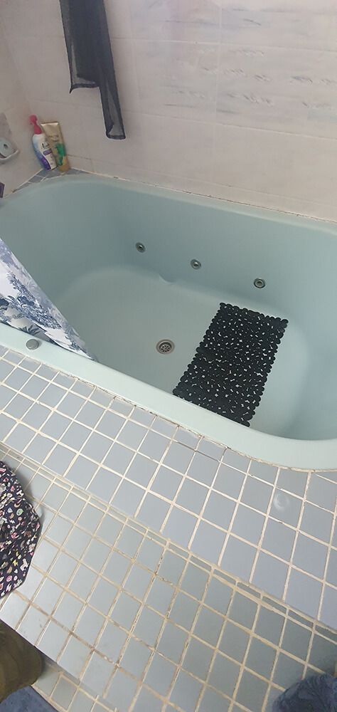 A Bathroom With a Tub , Shower Curtain , and Toilet — Omni Builders In Bungalow, QLD