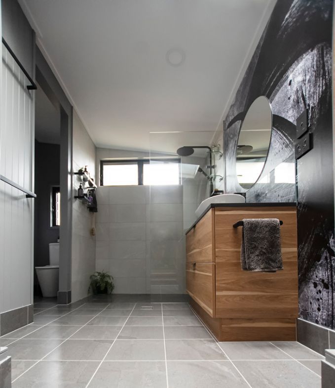 A Bathroom With a Sink , Mirror , and Toilet — Omni Builders In Bungalow, QLD