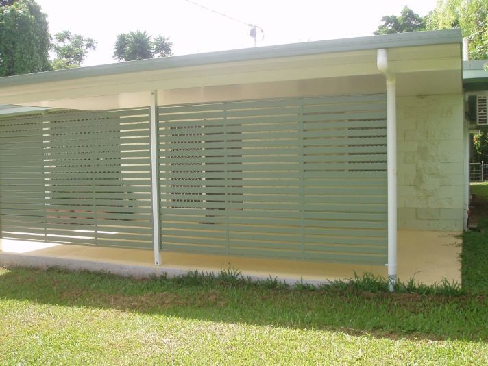 A House With a Covered Porch and a Lawn in Front of It — Omni Builders In Bungalow, QLD