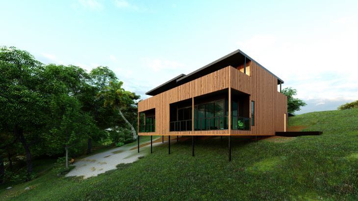 A Wooden House is Sitting on Top of a Grassy Hill Surrounded by Trees — Omni Builders In Bungalow, QLD