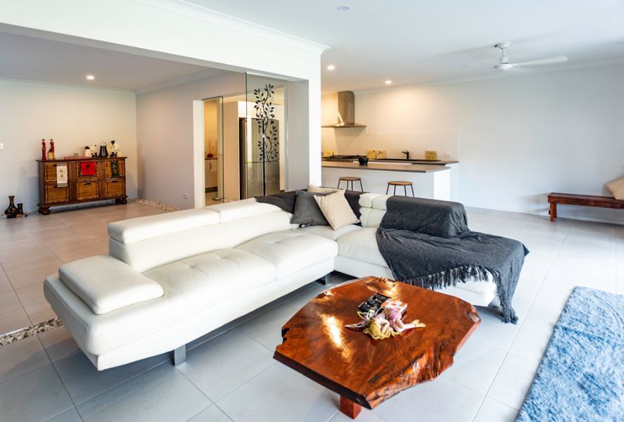 A Living Room With a White Couch and a Wooden Coffee Table — Omni Builders In Bungalow, QLD