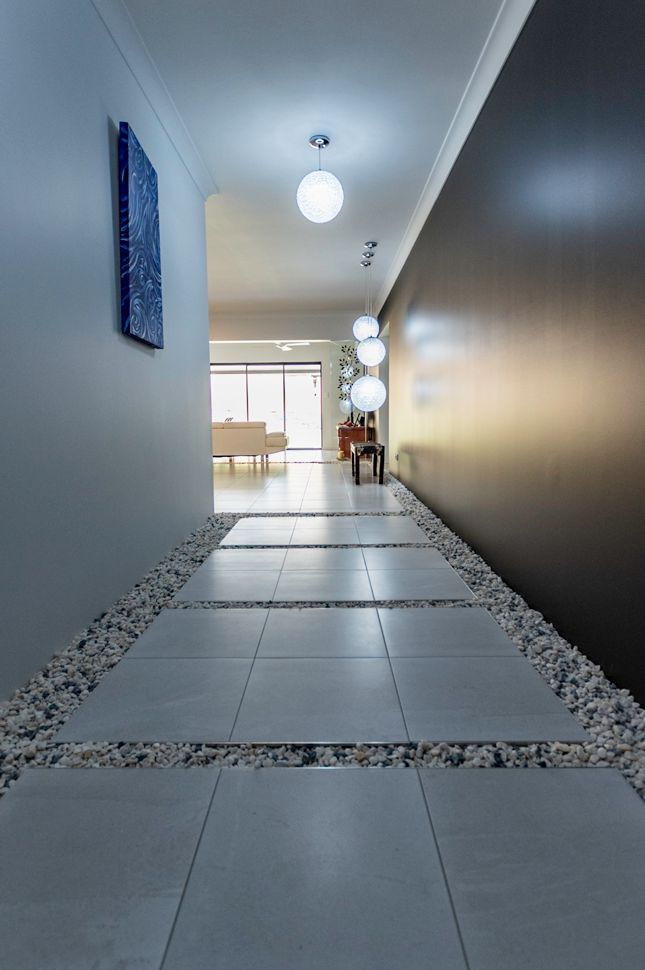 A Hallway in a House With White Tiles and Rocks on the Floor — Omni Builders In Bungalow, QLD
